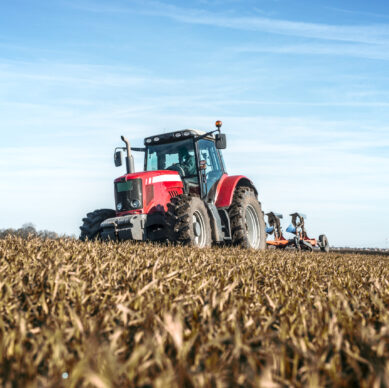 Tractor agricultural machine cultivating field.