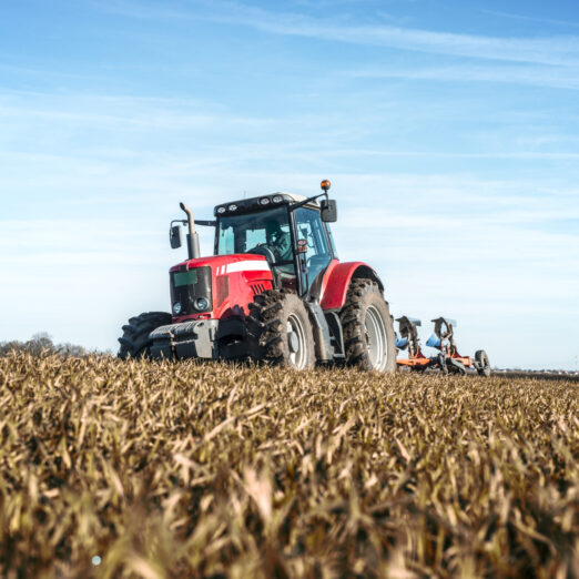 Tractor agricultural machine cultivating field.