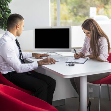 front-view-car-dealer-sellers-office-doing-paper-work